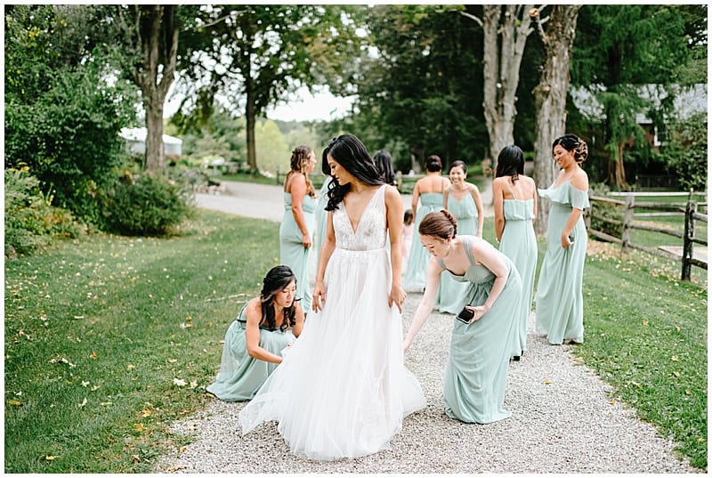 bridesmaids helping the bride with her dress