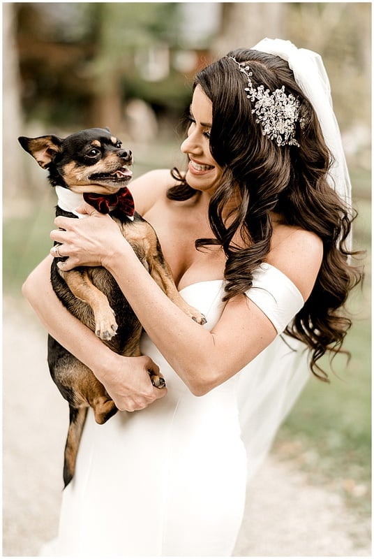 bride holding her little puppy before the wedding
