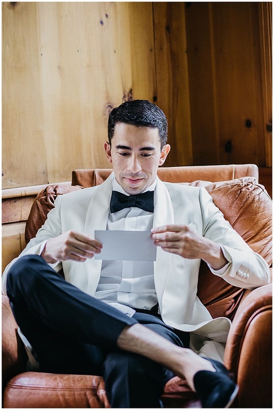 groom reading a card before the ceremony