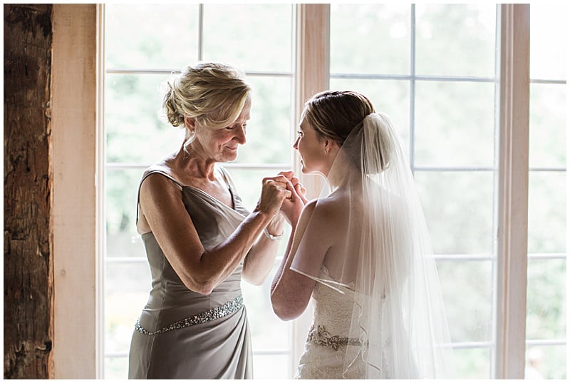 bride holding hands with her mom before the wedding