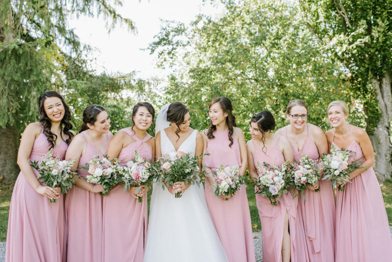 bride and bridesmaids pose with their bouquets of flowers