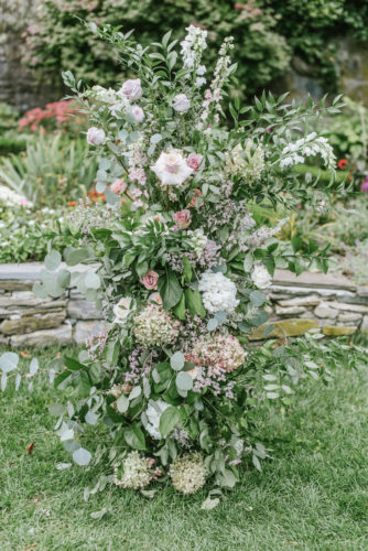 floral decor made of greenery, white, and peach flowers