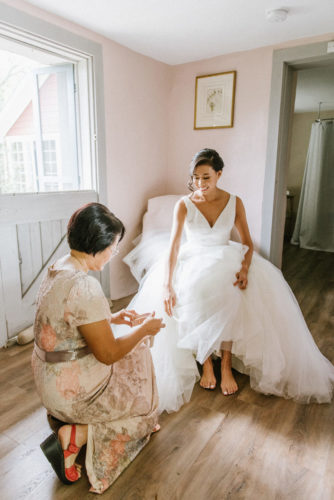 mom helping bride put shoes on