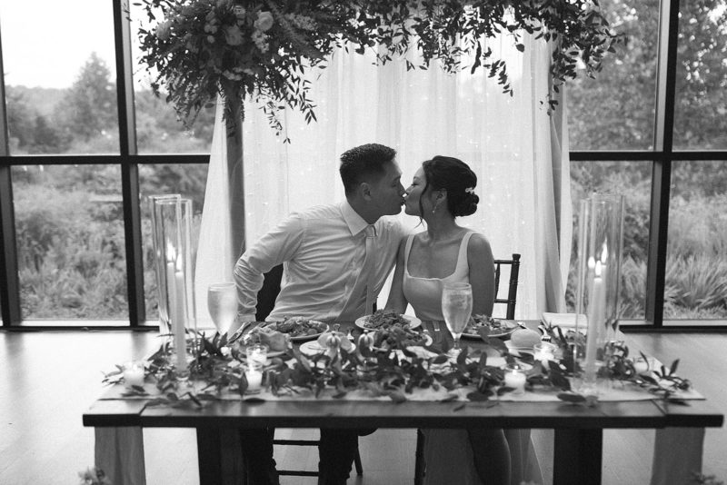 bride and groom kiss at the head table