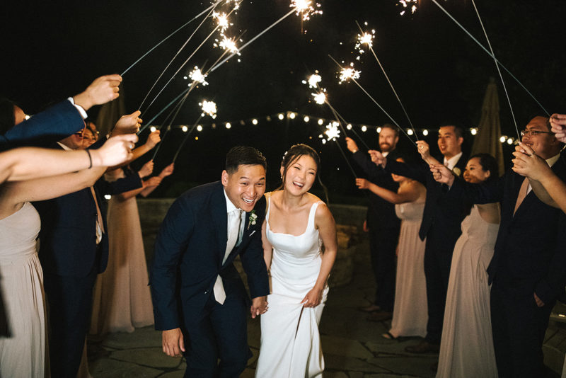 bride and groom walk through sparklers