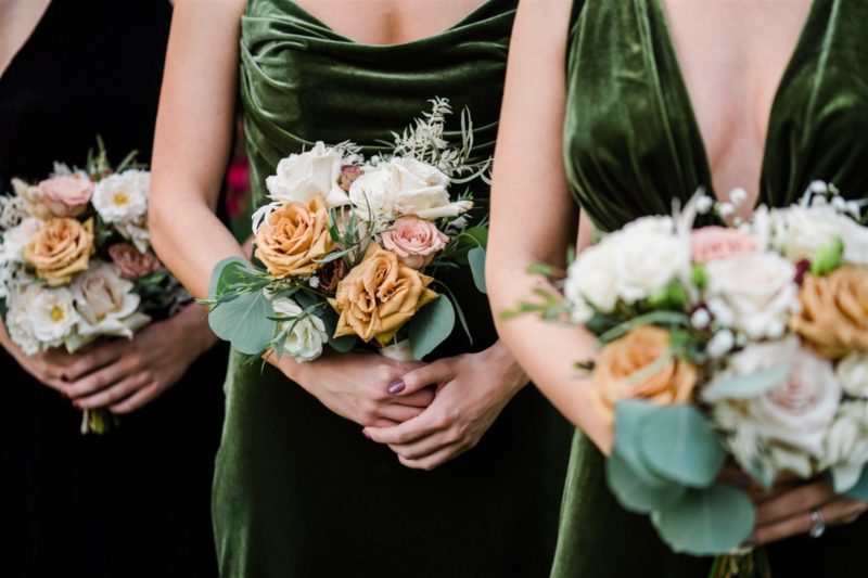 bridesmaids in green velvet dress holding bouquet