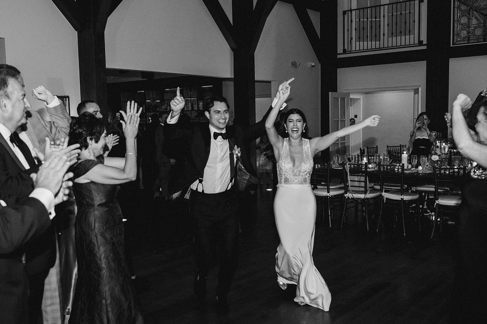 bride and groom enter the reception with arms up