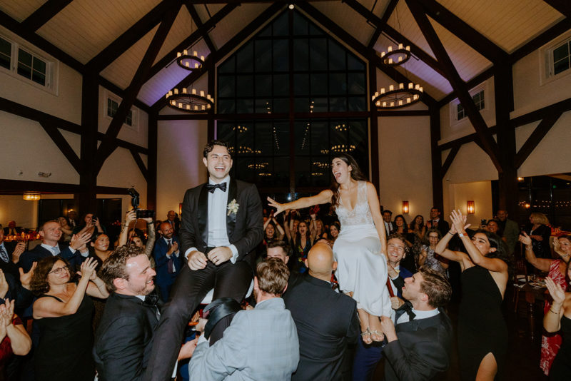 bride and groom lifted on chairs on the dance floor