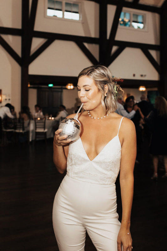 bride sips out of disco ball cup