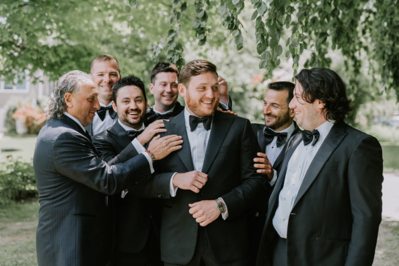groom and his groomsmen smile together for a picture