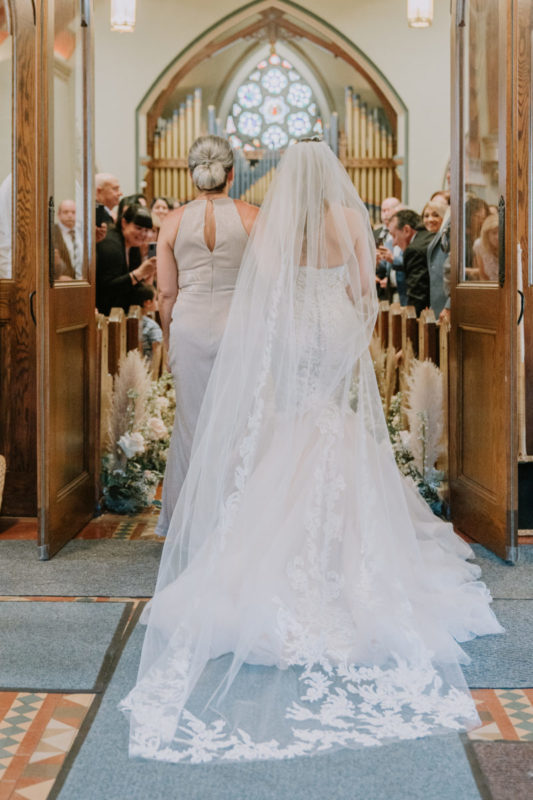 mom walks bride down the aisle in church