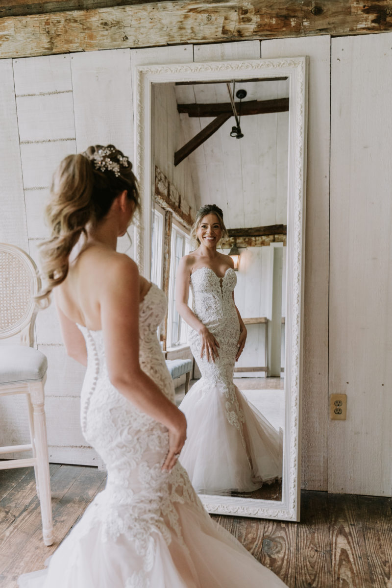 bride looking into a mirror with her wedding dress on