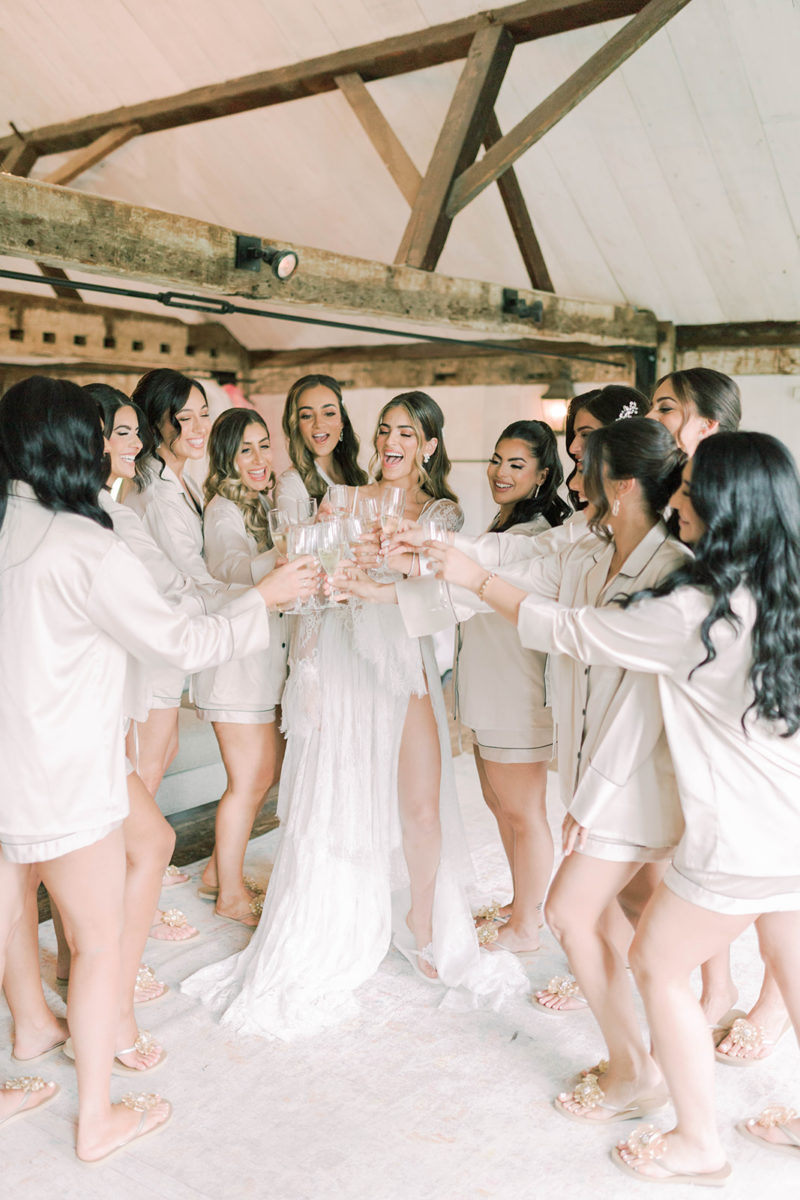 Bride and bridesmaids clinking their champagne glasses in the bridal suite
