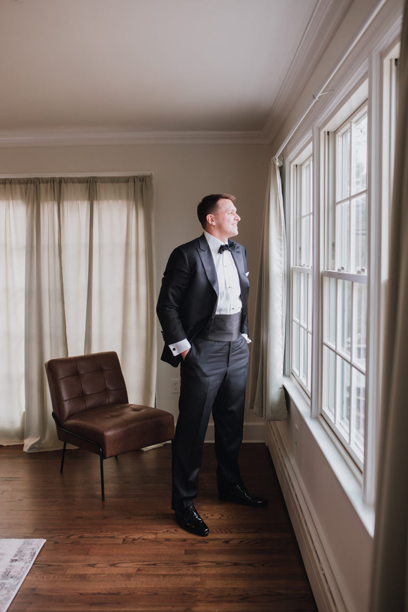 Groom looking out window at Pequest Parlour