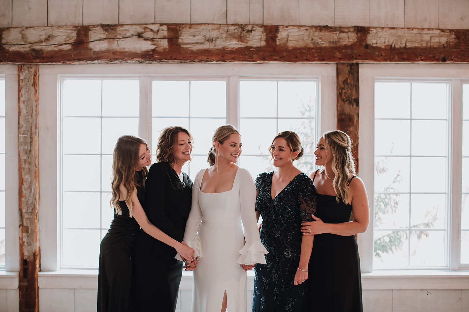 Bride and her bridesmaids posing together in the bridal suite