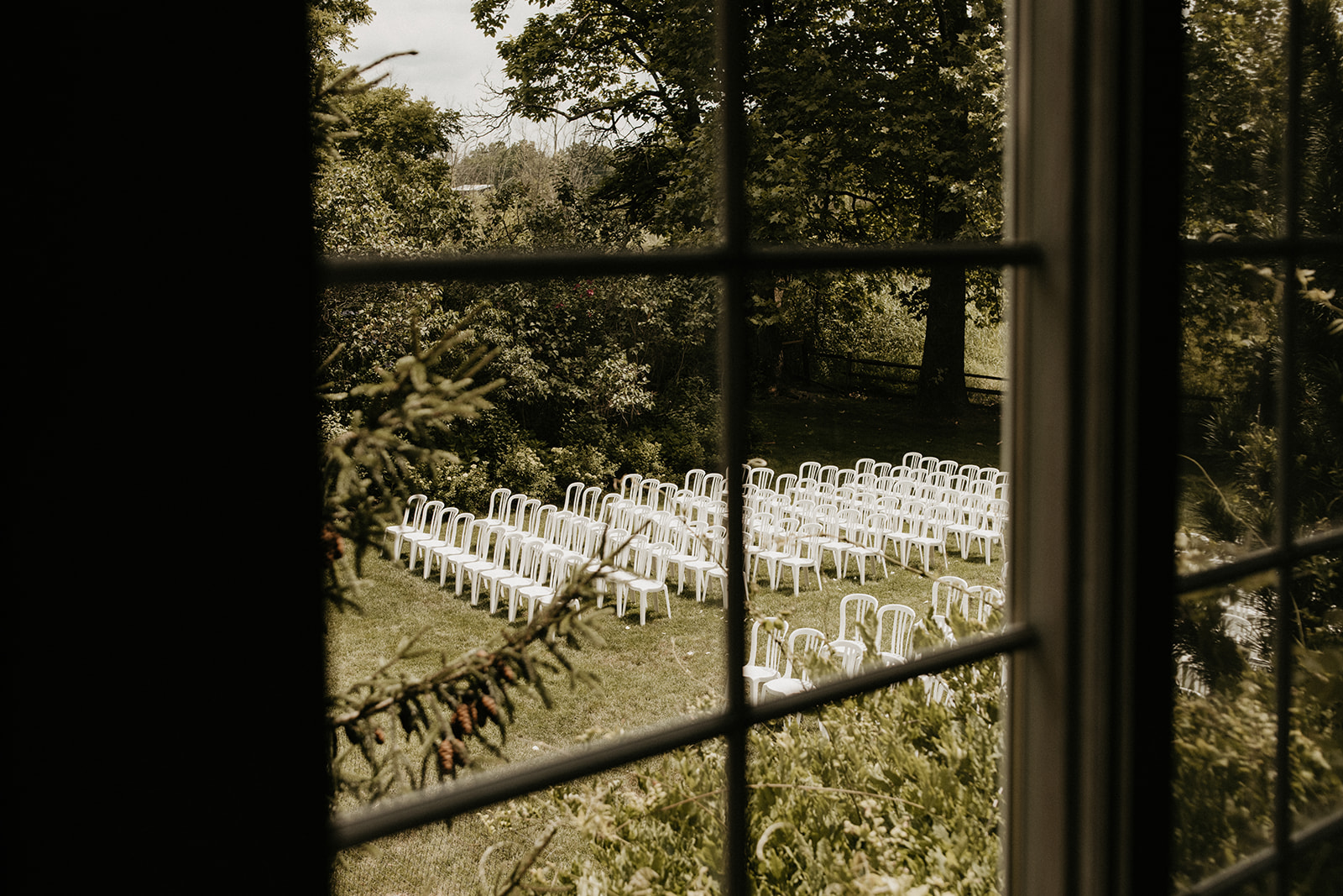 view of a wedding ceremony set up through a window