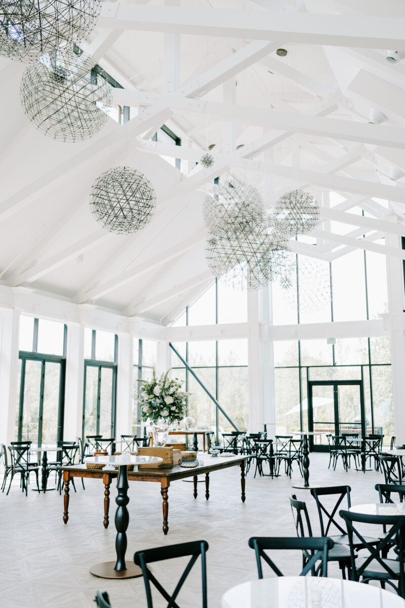 all white ceiling and beams support glass walls of a modern conservatory