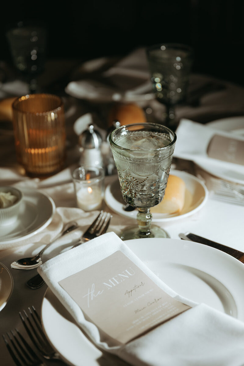 Wedding Reception Table Design with custom menu, folded napkin, water goblet and candle light