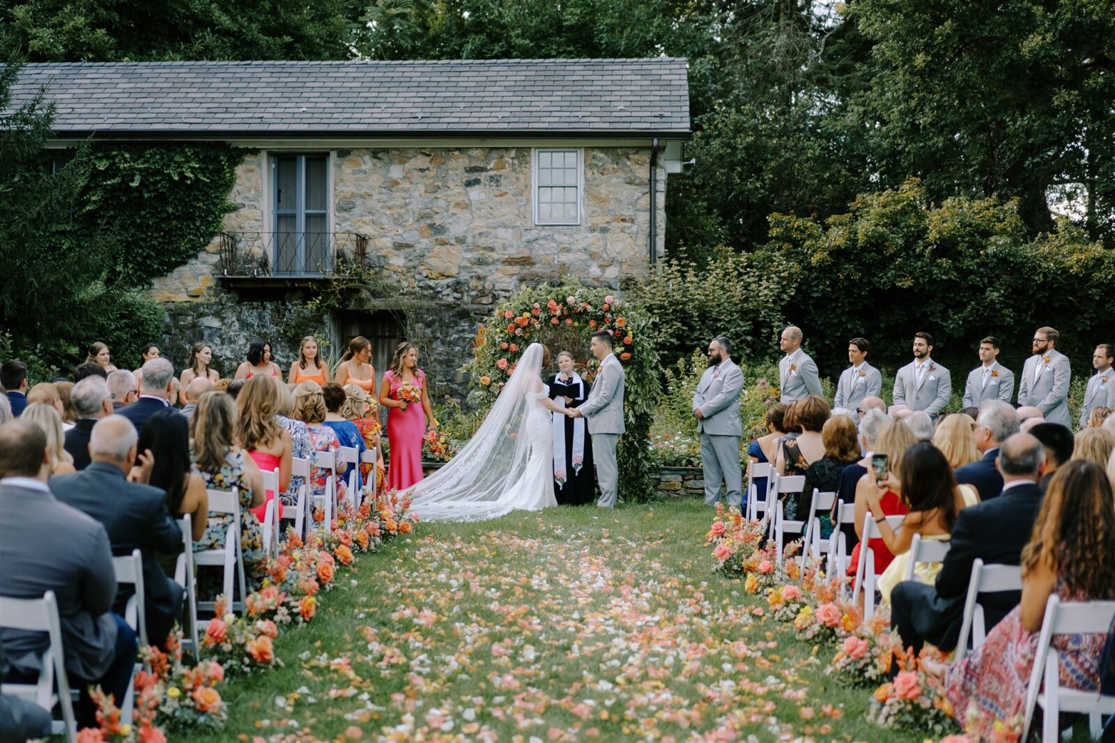 Garden Ceremony with vibrant sunset colored petals.