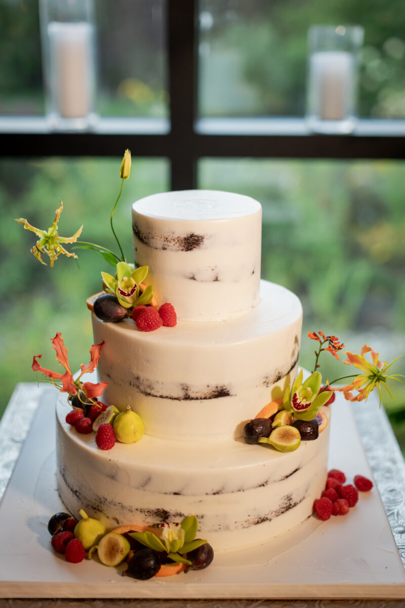 Close photo of a Wedding Cake decorated with orchids and fruit