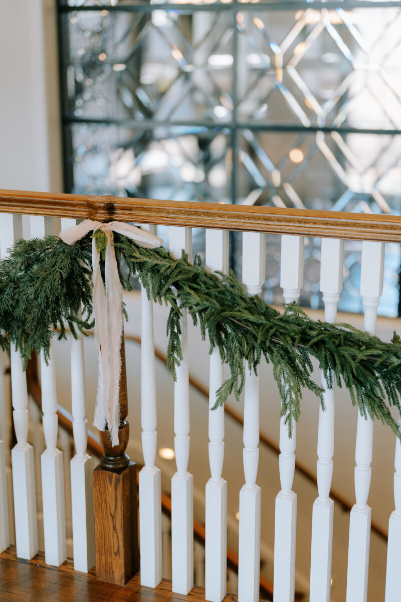 Farmhouse entrance decorated with wreaths, garlands, and twinkling trees for December wedding
