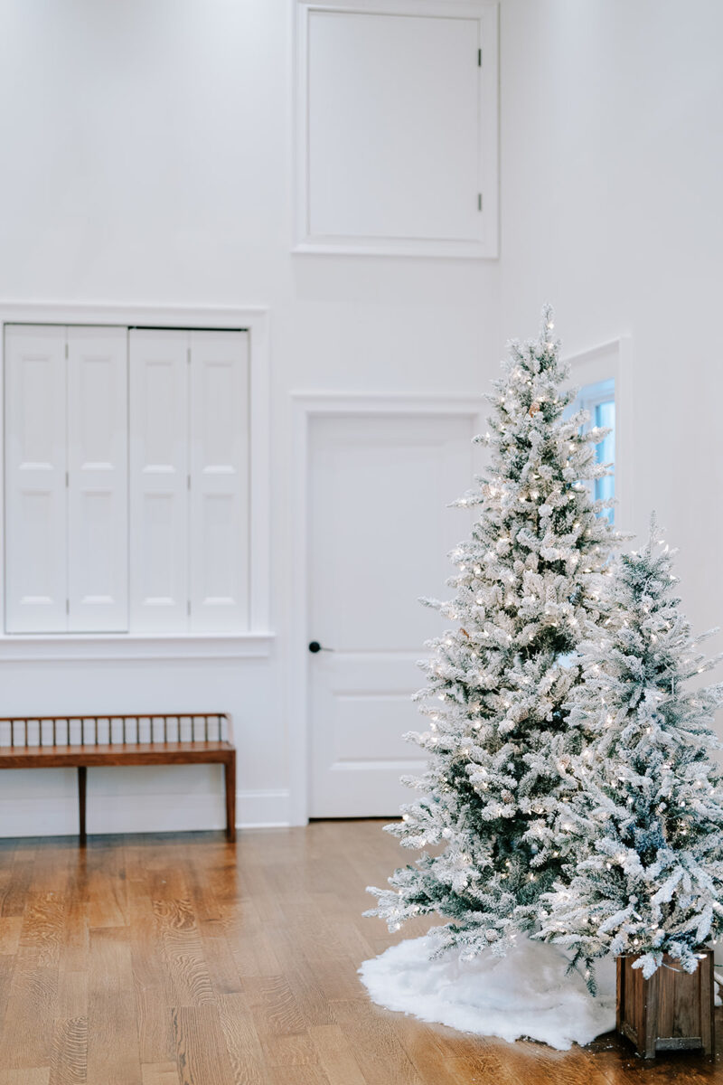 Farmhouse entrance decorated with wreaths, garlands, and twinkling trees for December wedding