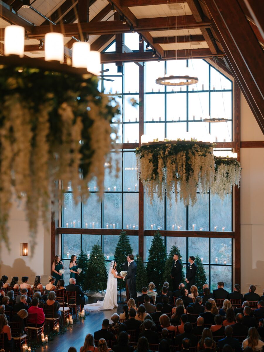 White wisteria hanging in Farmhouse chandeliers. Winter wedding reception