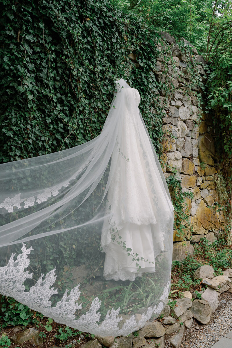 Bride’s Anne Barge lace wedding gown and veil hanging from the stone landscape