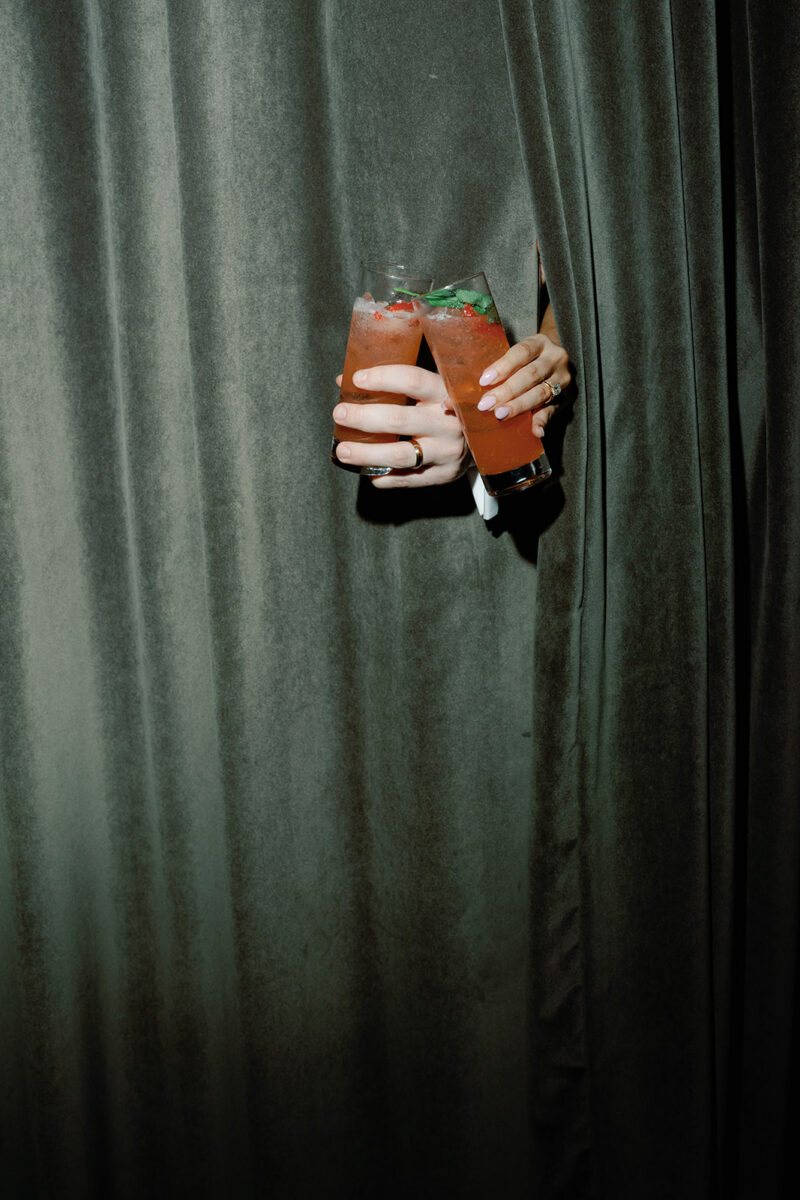 Newlyweds sharing strawberry margarita signature cocktails. Reception cocktails