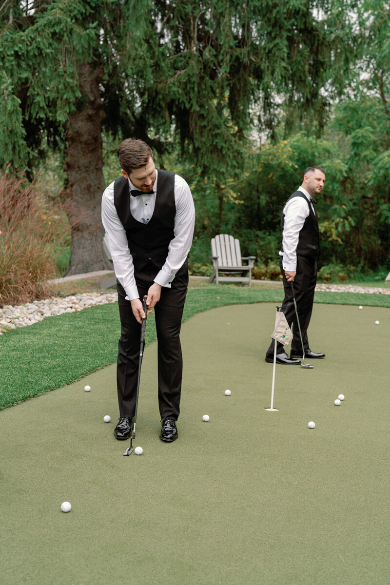 Groom putting golf balls on putting green at Crossed Keys Estate. Getting ready space with outdoor activities