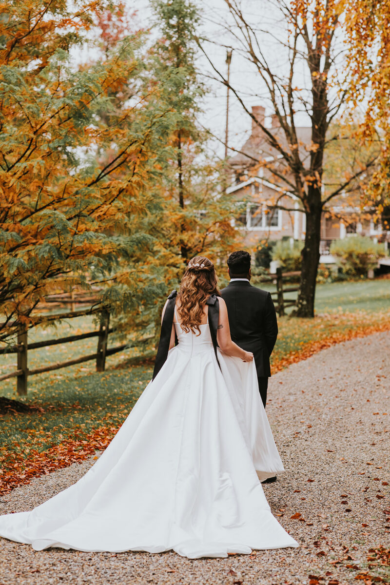 Bride and groom's second look in white ballgown with black bows, groom in black suit on Crossed Keys Estate's private driveway. Secluded private wedding venue
