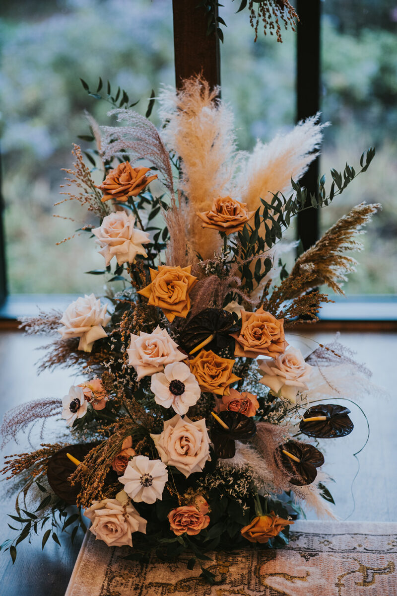 Black anthurium, Pampas grass, roses and anemone fall wedding florals moody boho ceremony at Crossed Keys Estate
