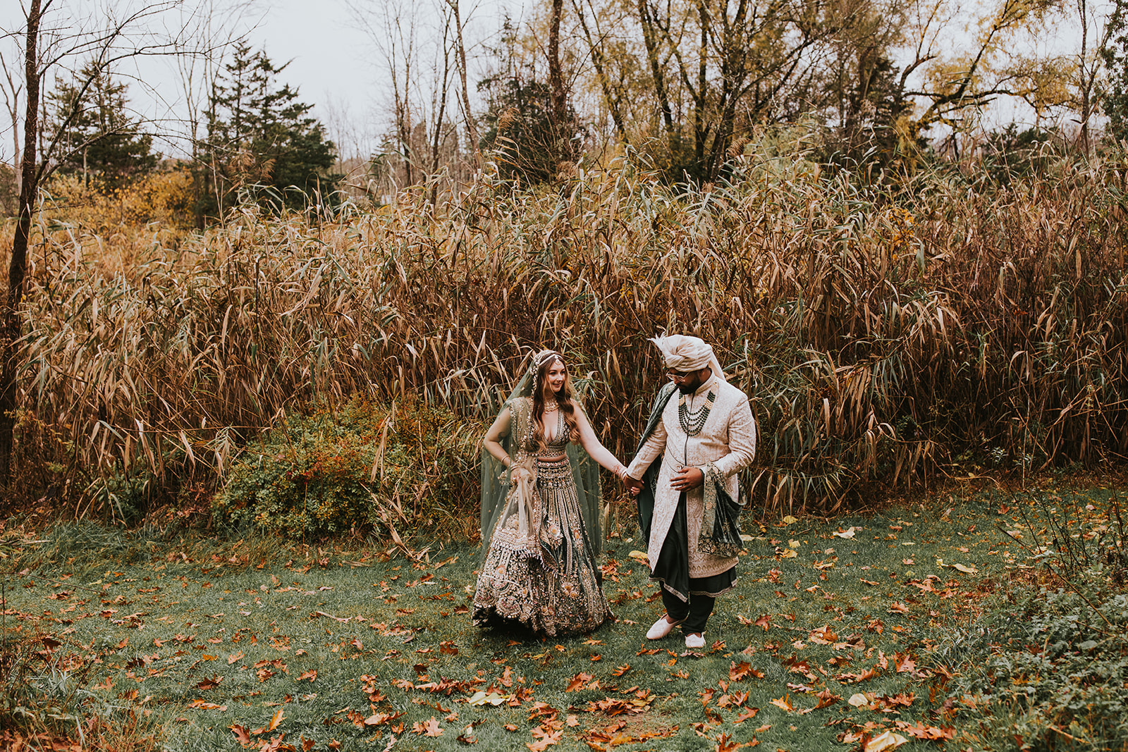 Couple walking through fall leaves portraits upscale NJ garden wedding venue
