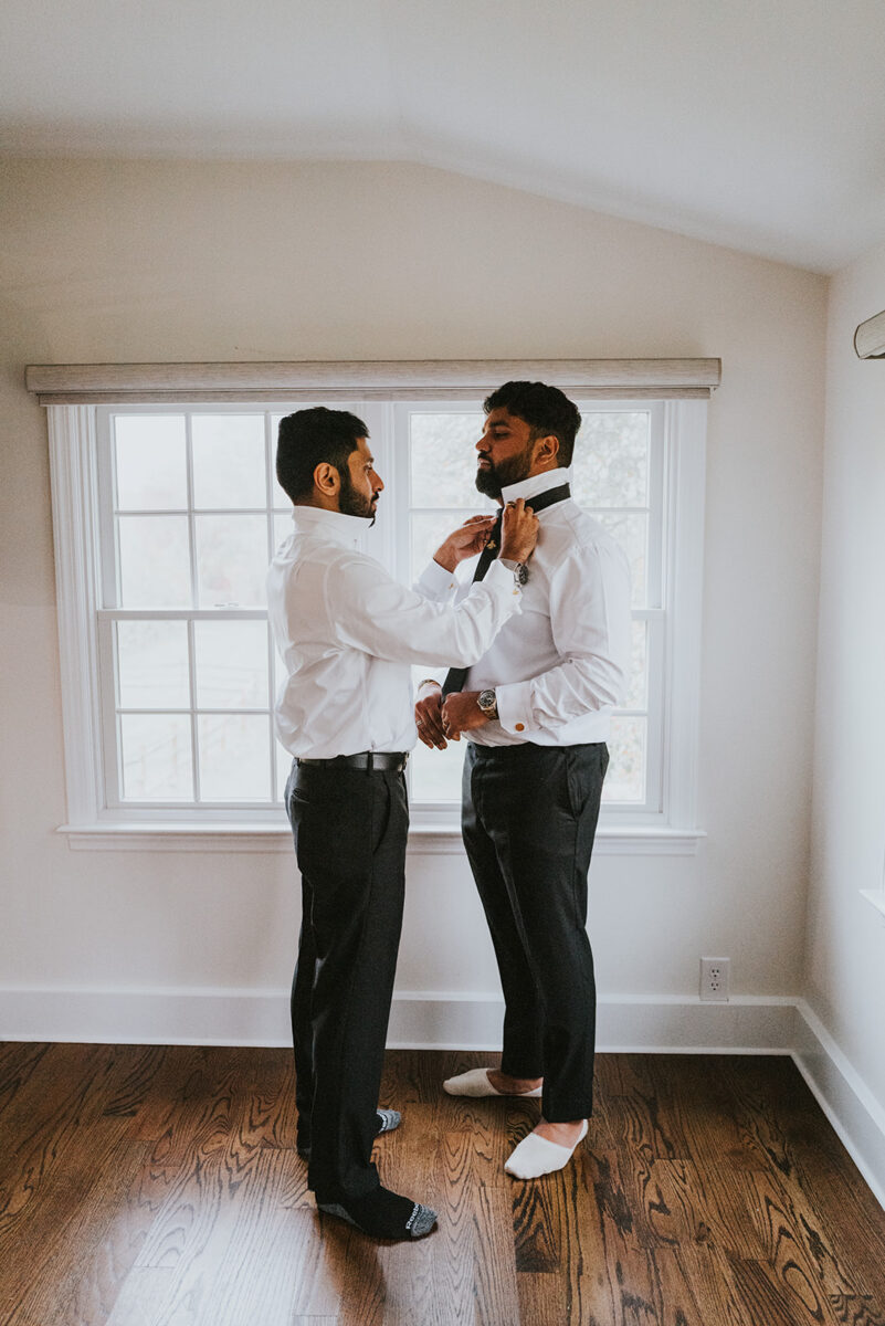 Groom changing in the parlor before second look and wedding ceremony