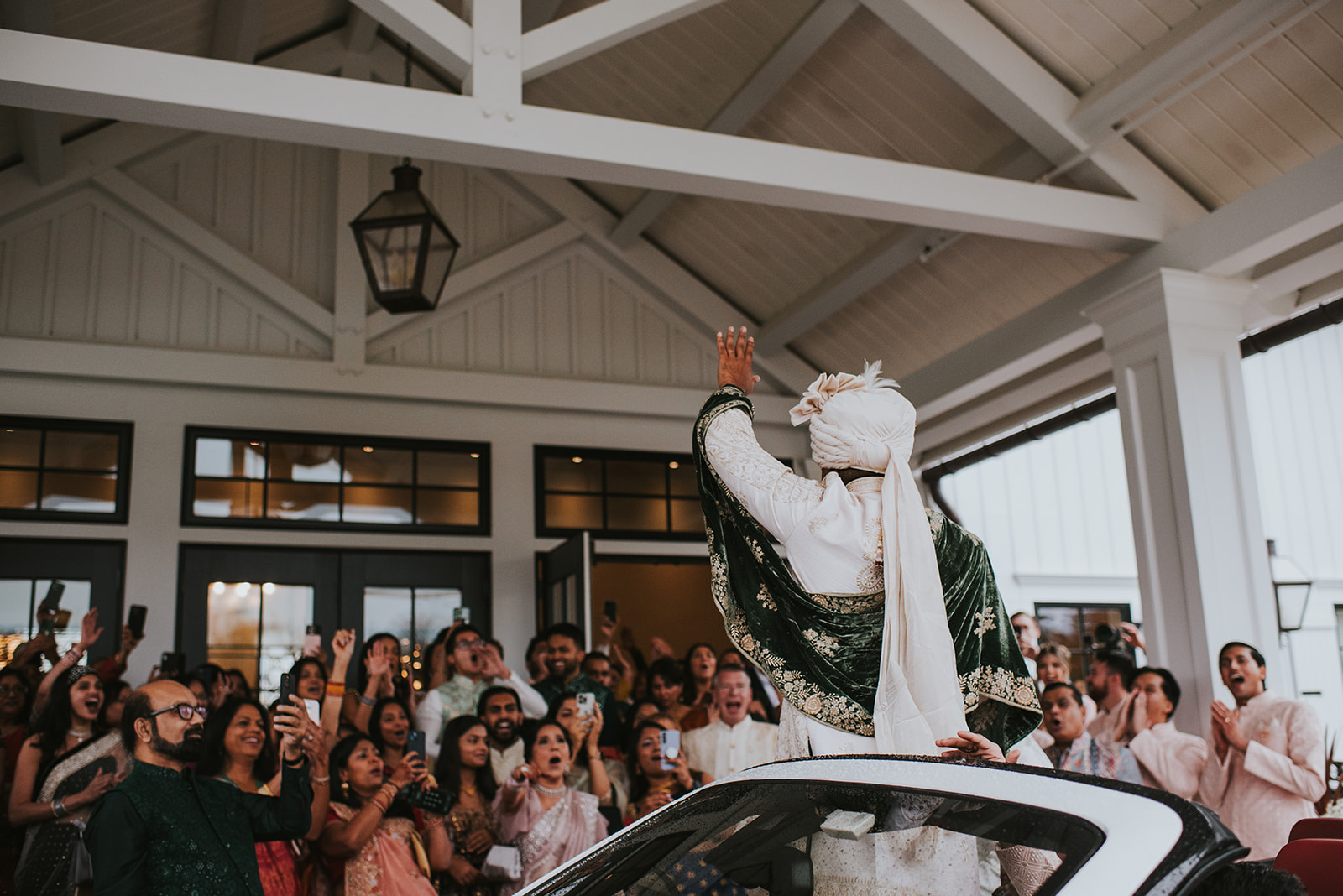 Indian wedding baraat celebration with groom in embroidered sherwani at New Jersey garden estate