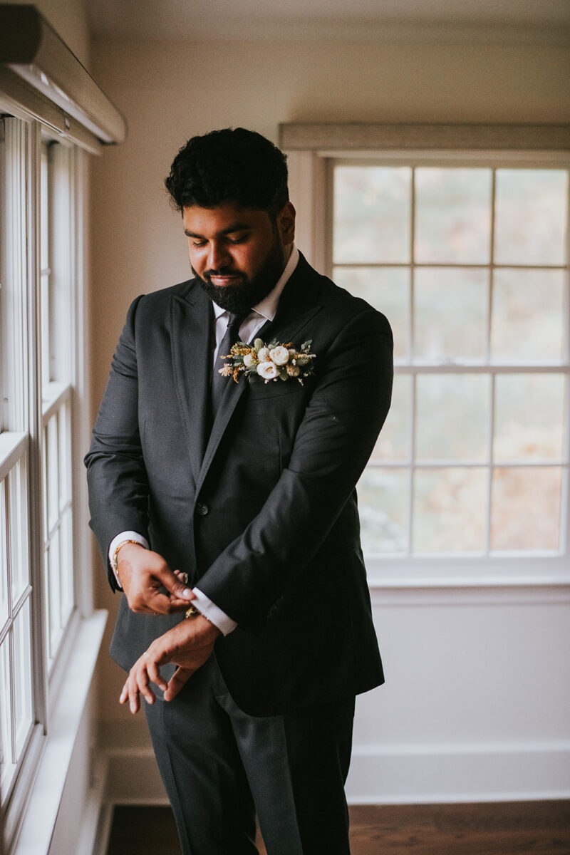 Groom changing in the parlor before second look and wedding ceremony