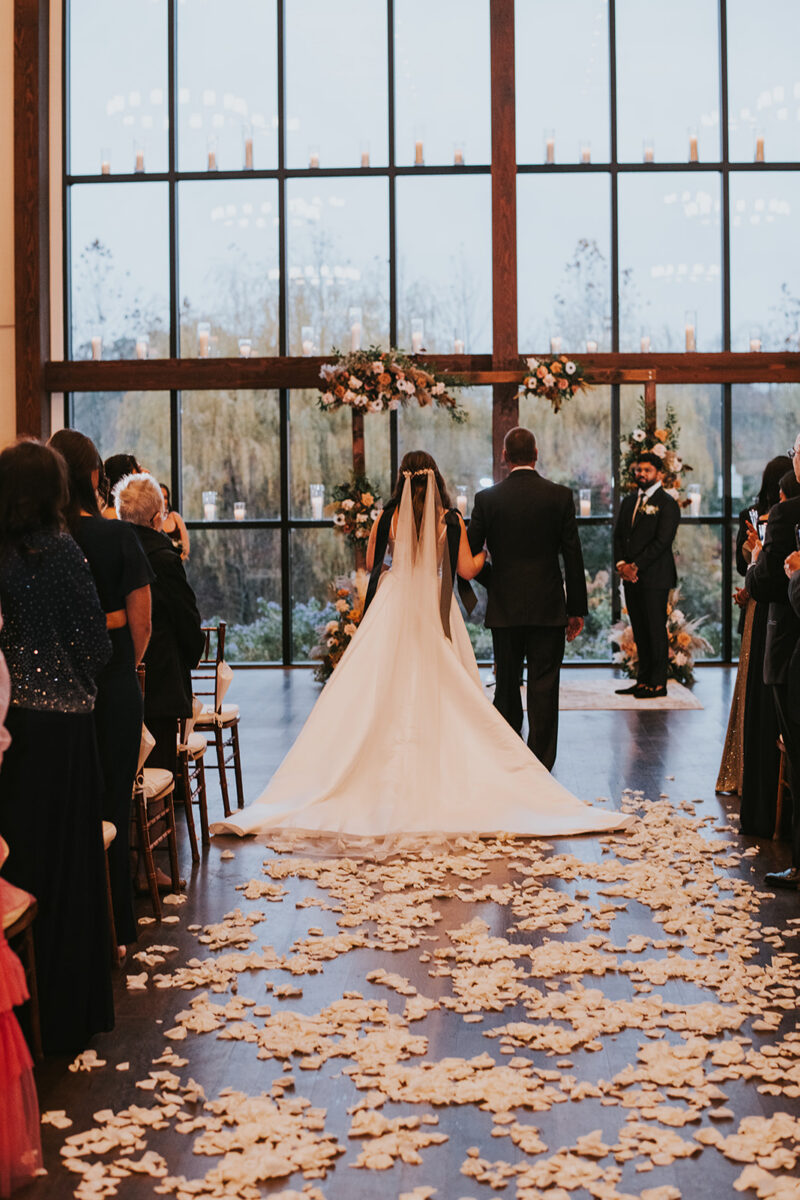 Bride in Galia Lahav ballgown black bow details walking down aisle at Crossed Keys Estate Hindu-American wedding New Jersey