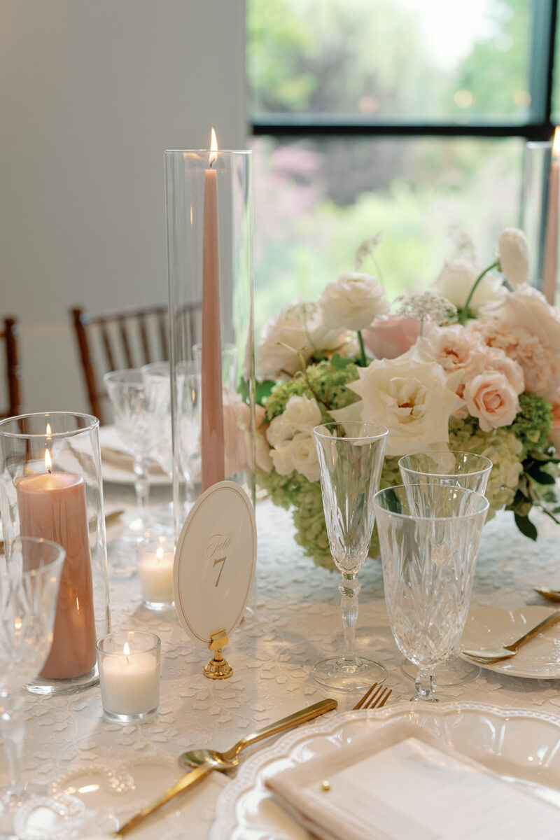 Lush floral vase with desert rose taper candles on reception table
