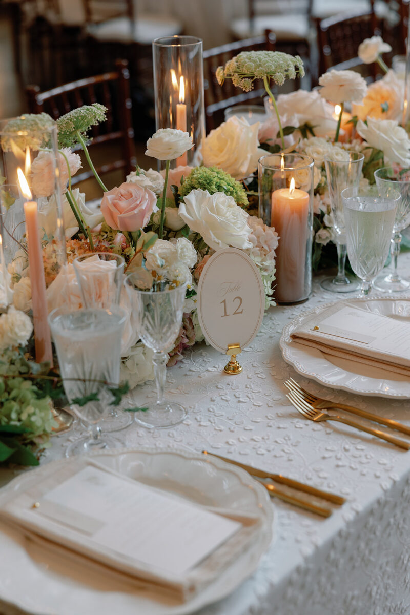 Lush floral runner with desert rose taper candles on farmhouse reception table